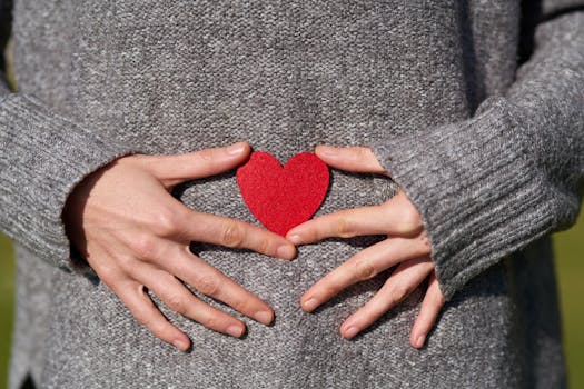 hands holding heart-shaped paper